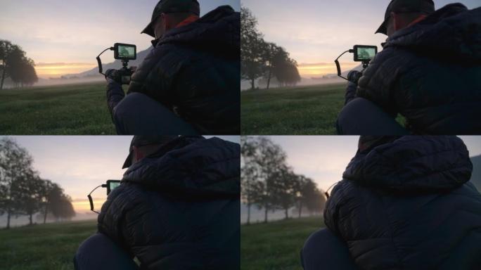 黎明景观中带监视器的人调整相机
