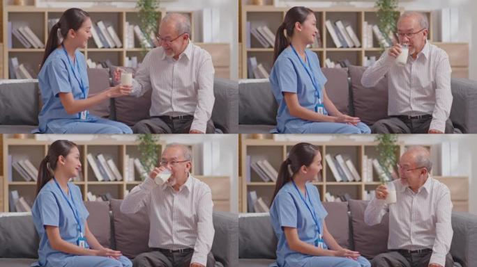 亚洲美丽的治疗师医生为疗养院的老年患者提供牛奶。穿着制服的亚洲护士协助老年男子坐在沙发上喝牛奶。