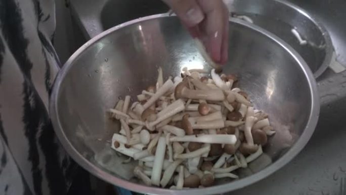 厨师洗Shimeji，在厨房烹饪的生蘑菇