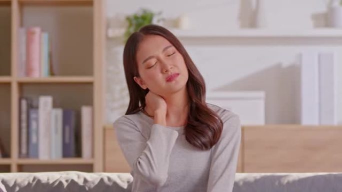 一个亚洲女人在她的脖子和肩膀上做自我按摩。她背部疼痛，肌肉疼痛。按摩可以帮助她缓解疼痛，但最好的方法