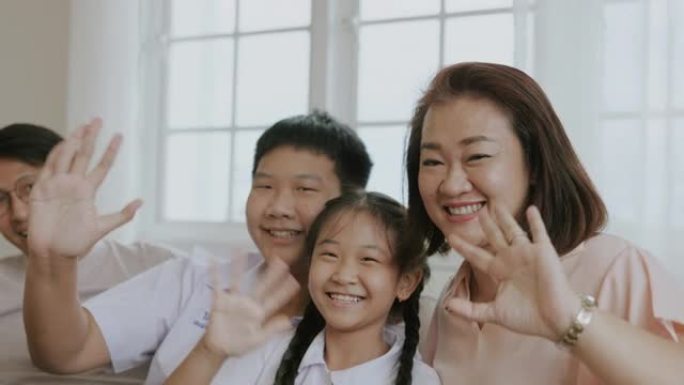 欢乐时光，亚洲家庭挥舞着露齿微笑的手。