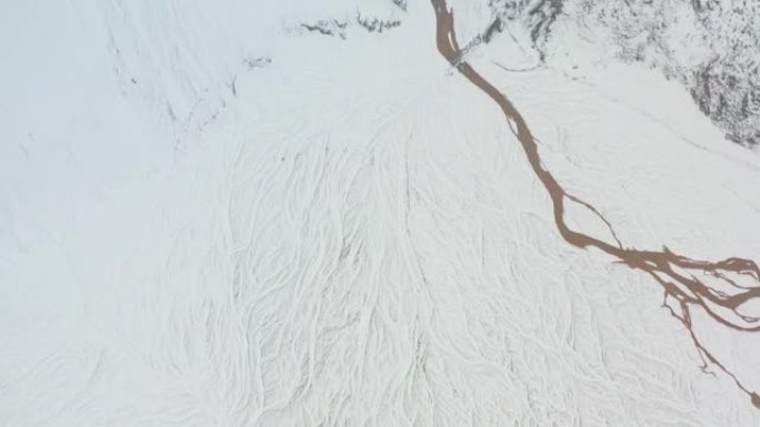 无人机覆盖着冰雪覆盖的景观，冰冻的编织河床