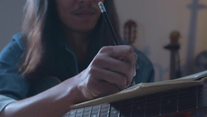 关闭亚洲音乐家在笔记本上写一首歌