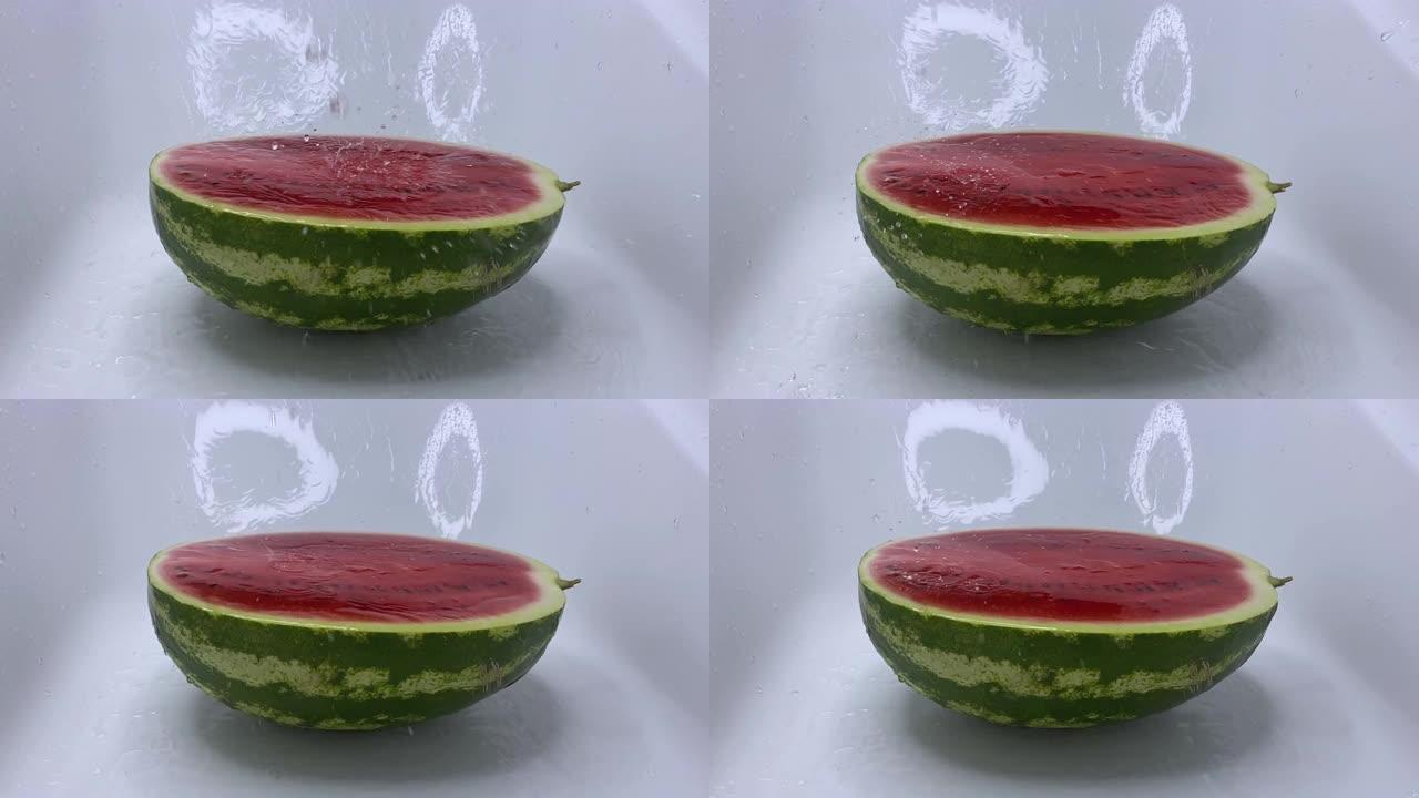水流落在多汁的红色成熟西瓜上，切成两半，滴入
