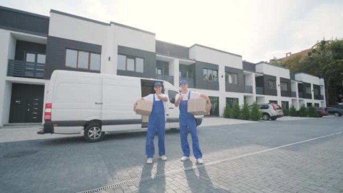 搬迁公司的两名年轻工人将箱子运送到客户的家中