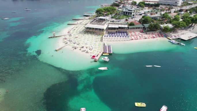 空中，带空日光浴躺椅和船只的蔚蓝海滩，巴尔干海岸，阿尔巴尼亚