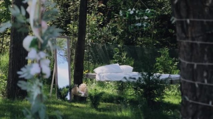房子的院子里，一个带床垫和镜子的秋千站在大自然旁边。非常愉快的气氛