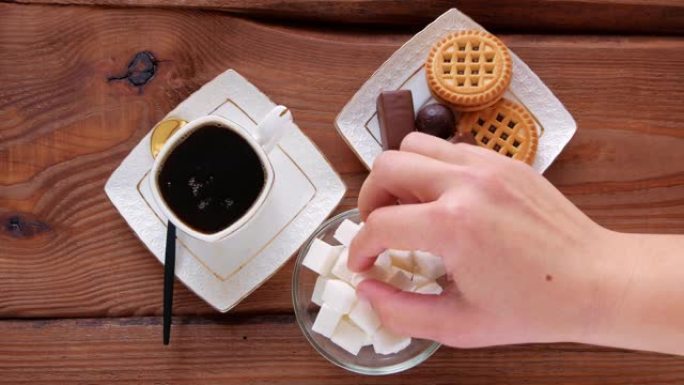 在蒸咖啡木桌上加入方糖。热的新鲜酿造的咖啡杯。松脆饼干巧克力糖果糖果盘子。餐厅饮料早餐菜单糖尿病疾病