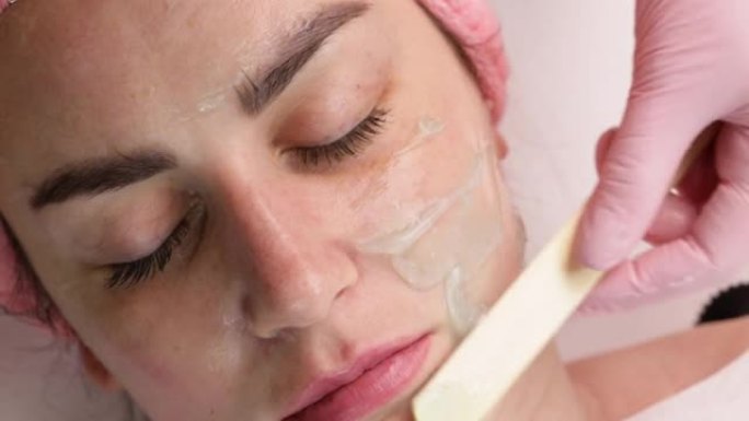 美容师制作生物发光射频提升程序。恢复皮肤活力，防止衰老，女人得到刺激美容面部护理。现代诊所的硬件美容