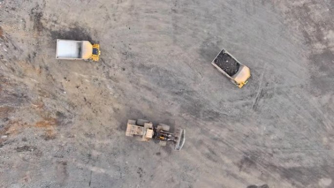 装满石灰石矿石的重型自卸车沿着采石场的道路行驶