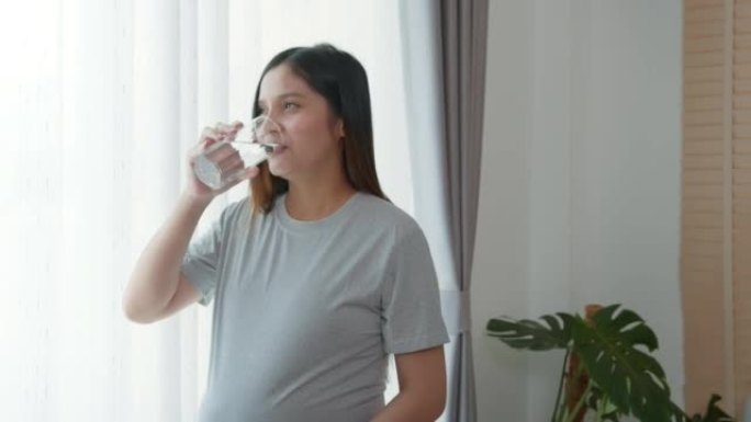 年轻孕妇在家喝水，保健和怀孕护理理念