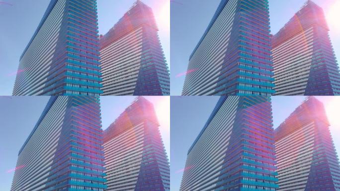 在城市摩天大楼的玻璃窗上拍摄太阳，云彩和天空的反射。