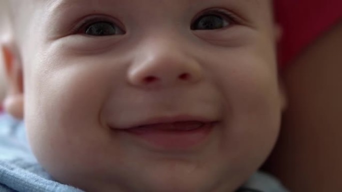 早期婴儿的特写笑脸醒来睁开眼睛。婴儿穿着蓝色紧身衣做梦后做鬼脸。微距生活肖像的第一分钟的孩子。童年，