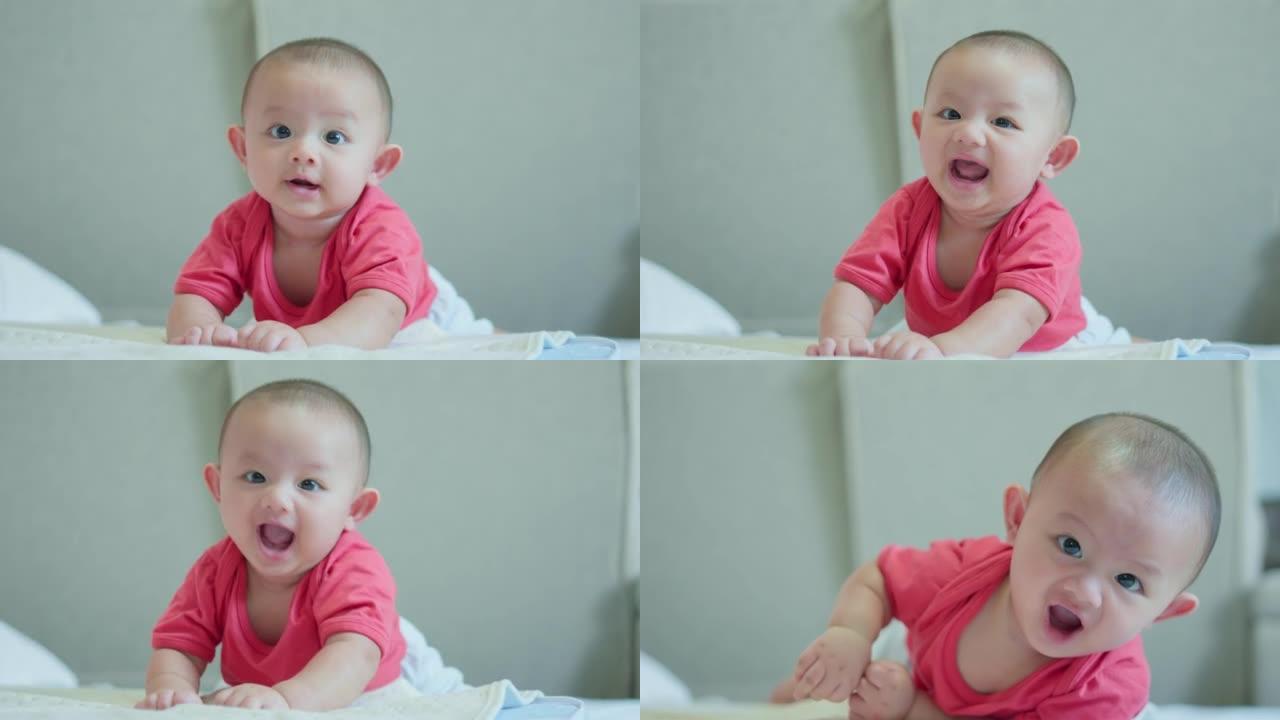 幸福的家庭，可爱的亚洲新生婴儿穿着红色衬衫躺在白色床上玩耍，笑容满面。小天真的新生婴儿可爱的孩子在生