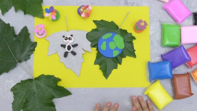 儿童用橡皮泥、纸和天然叶子制成卡片。保护环境，拯救我们的星球。生态学概念。艺术学习和教育的概念