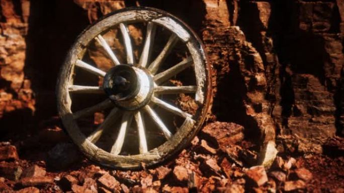 石头岩石上的旧木制手推车轮子