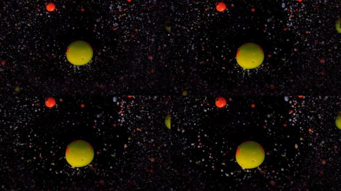 黑色背景上的圆形五彩球，银色亮片。白色、黄色和红色颗粒随机移动。