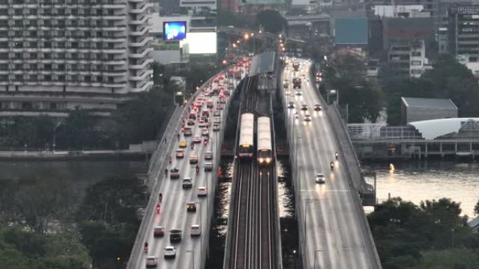 空中无人机在曼谷的超披亚河上的高速公路和地铁天空列车上的交通车灯的日出场景