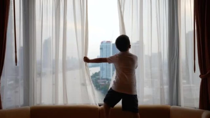 亚洲孩子在酒店拉开帷幕。开始新的一天，假期和发现的概念