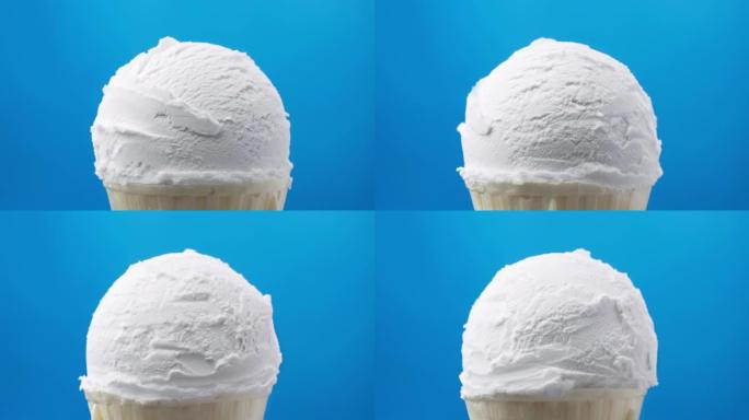 旋转香草冰淇淋在蓝色背景下的圆锥形。食品概念。