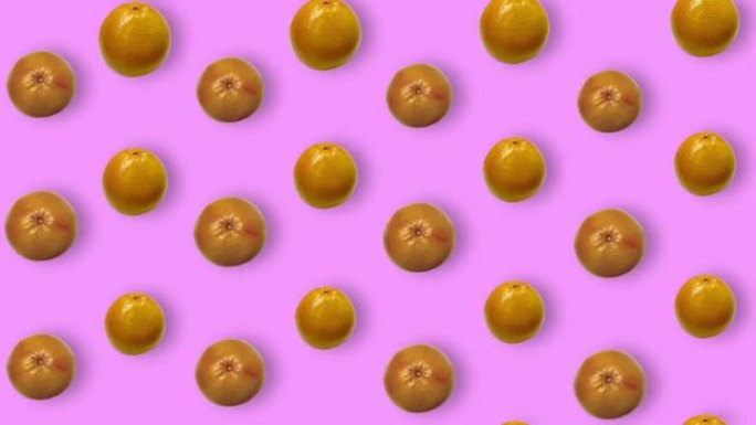 粉红色背景上的新鲜葡萄柚的彩色水果图案，带有阴影。葡萄柚无缝图案。逼真的动画。4k视频运动