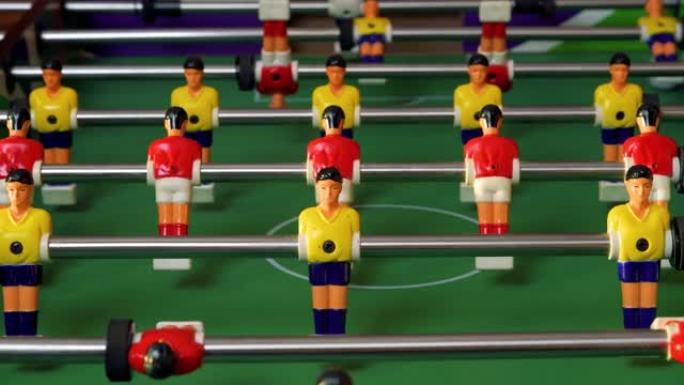 人们用红色和黄色可爱的塑料数字踢桌上足球。4k视频片段