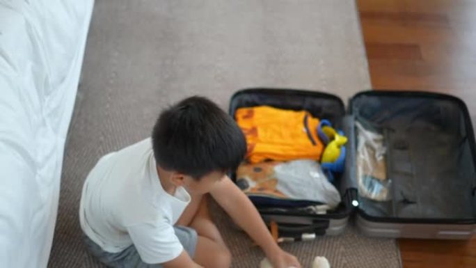 亚洲男孩收拾行李度假