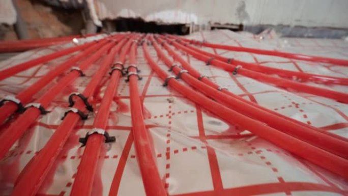 安装用于水加热的地板下加热管道。供暖系统。隔热地板用管道。