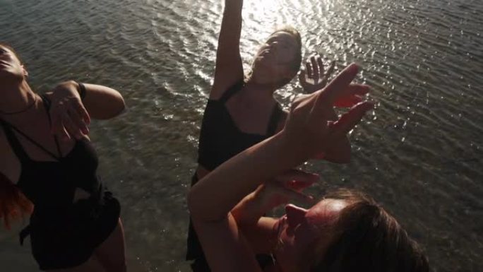 一群年轻的女性在日落慢动作时在海上狂喜跳舞