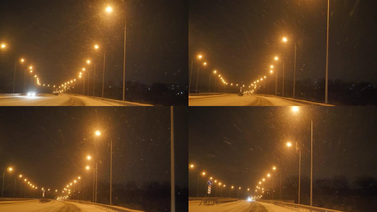 夜间飘雪空旷的马路，没有车流，一排明亮的路灯