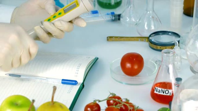 食品安全实验室，科学家概念。检查员从商店中提取用于分析的西红柿中提取硝酸盐样品。