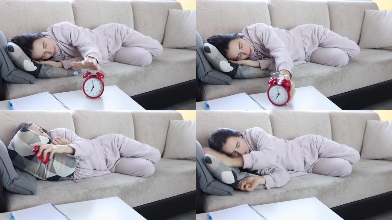 疲倦的熟睡女人躲在枕头下响起闹钟