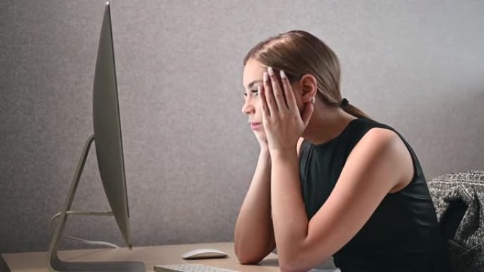 一个迷人的年轻女子的特写镜头，专心而紧张地看着办公室的电脑屏幕。现代合作开放空间中的女商人