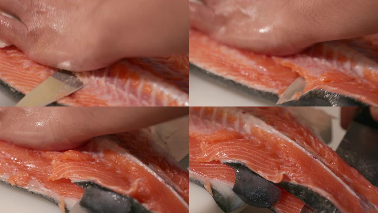 熟练的厨师将新鲜的鲑鱼肉上的脊椎骨切成薄片并分离成寿司