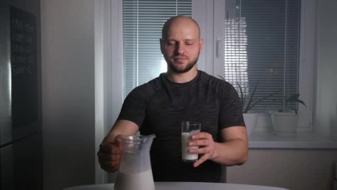 秃头的运动员将牛奶倒入厨房的玻璃杯中，喝酒并翻白眼