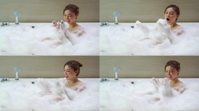 年轻女子在浴缸里玩泡泡浴