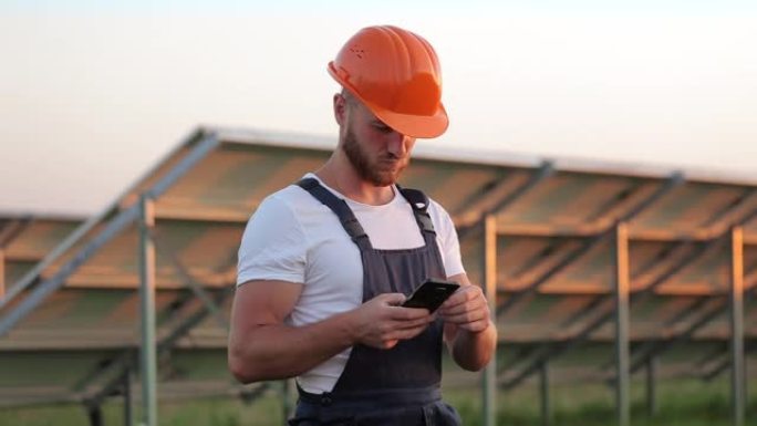 在太阳能农场使用智能手机的头盔工程师。