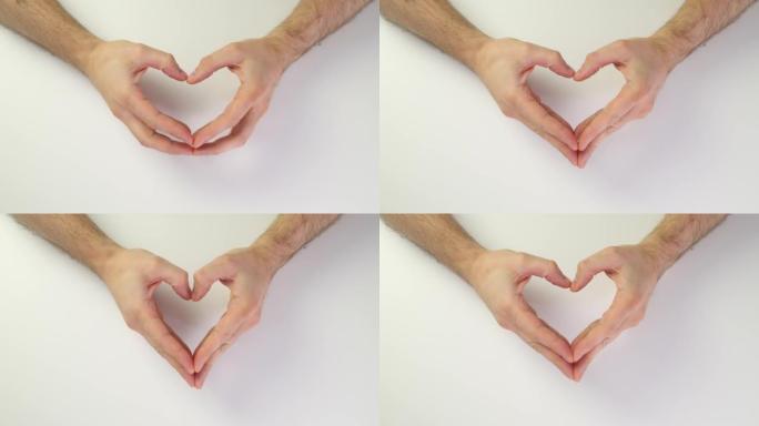 俯视图男性手创造一颗心。手指心脏符号。白色背景上的爱情标志。