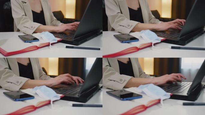 女商人用手在笔记本电脑笔记本键盘上打字。