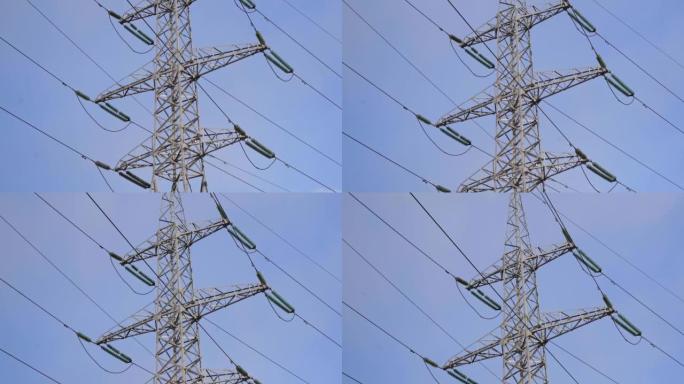 巨大的金属高压塔，带电线，仰视，摄像机缓慢移动，背景为蓝天