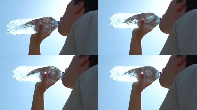 男人从塑料瓶里喝水。