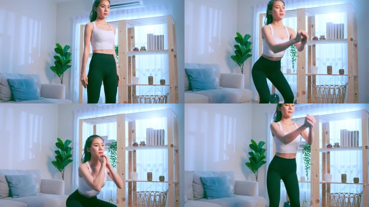 亚洲年轻美丽的积极运动女人在家做有氧运动。穿着运动服的迷人女孩用垫子在家里的客厅花免费的休闲时间锻炼