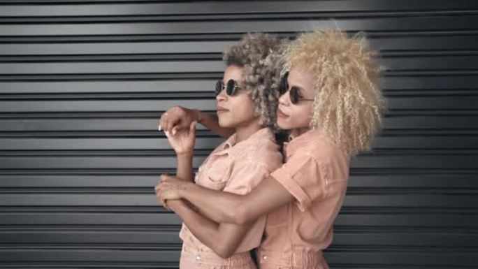 时尚的非洲裔美国姐妹，金发碧眼的非洲裔发型拥抱在一起，享受时光