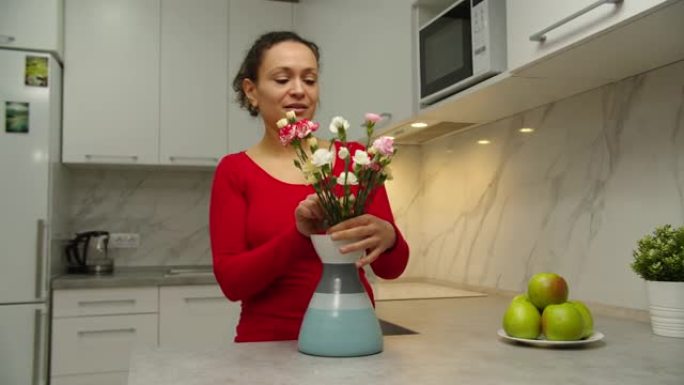 黑人妇女将花束放入花瓶中，在室内布置鲜花