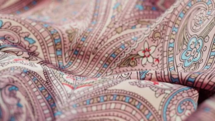 粉色真丝面料特写，阿拉伯图案或印度图案。布料纹理背景。纺织品的宏观拍摄
