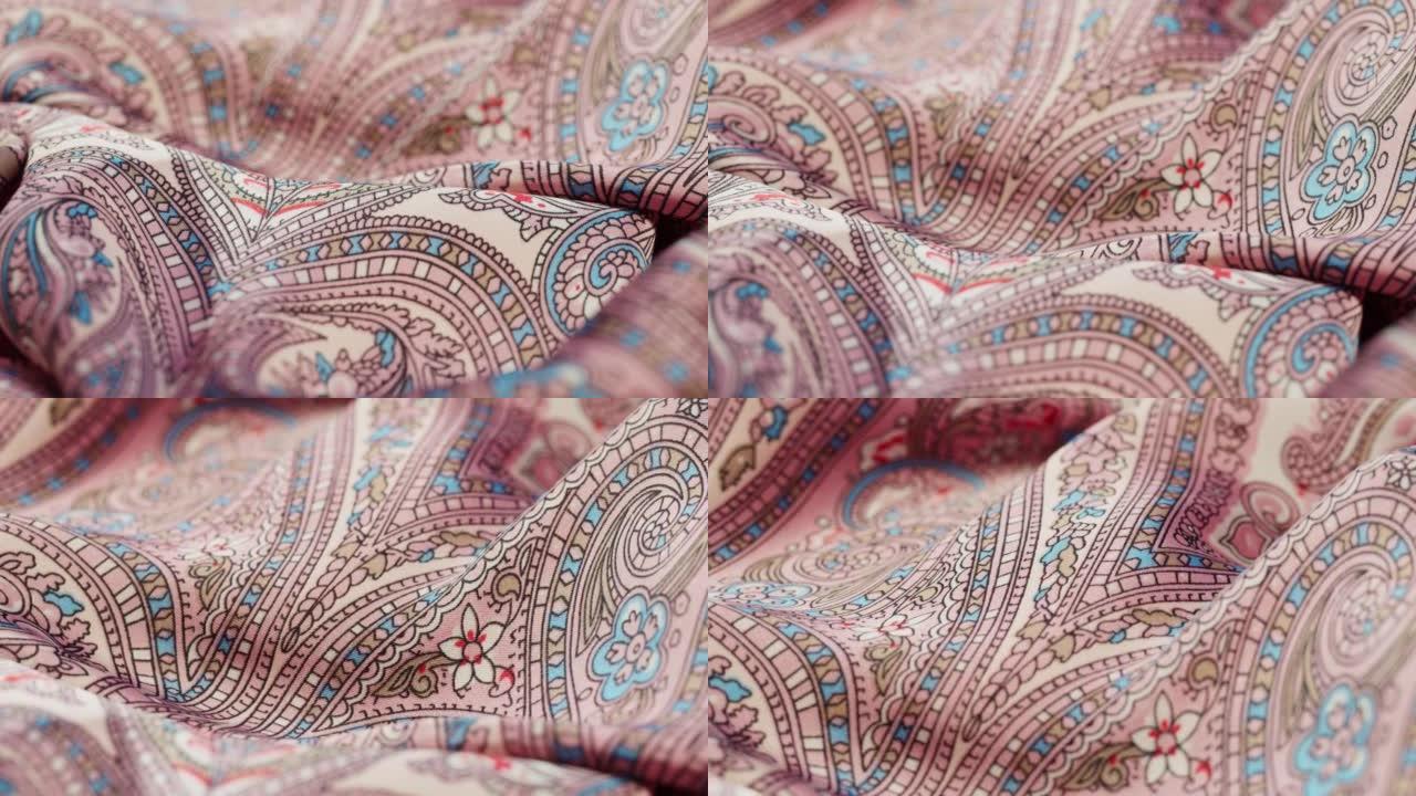 粉色真丝面料特写，阿拉伯图案或印度图案。布料纹理背景。纺织品的宏观拍摄