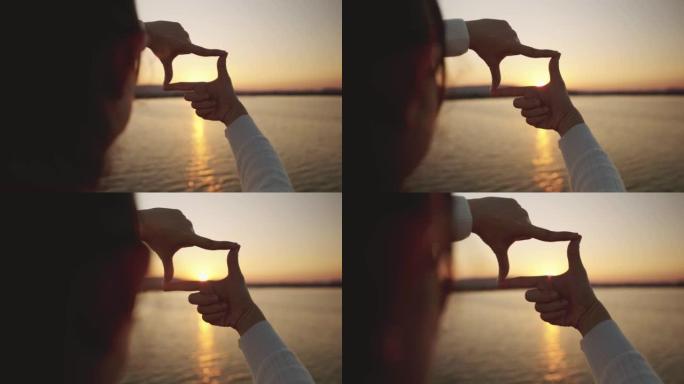 女人的双手用日落，新年计划和视觉概念制作框架手势，女性捕捉日出。