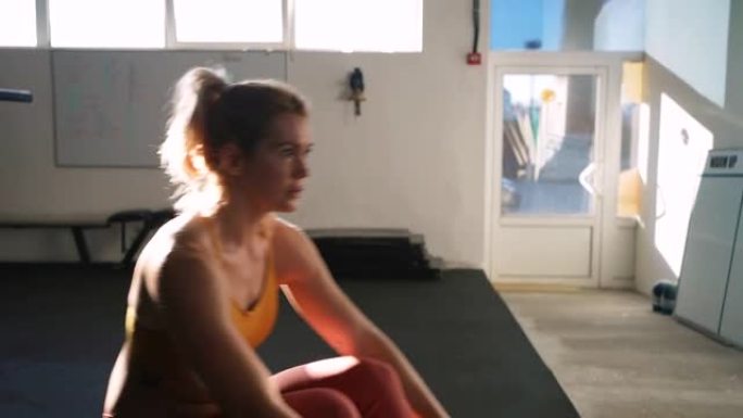 强壮的女运动员在健身房的划船机上锻炼