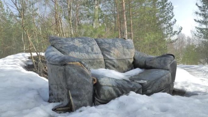 冬季在森林中废弃沙发的特写镜头。