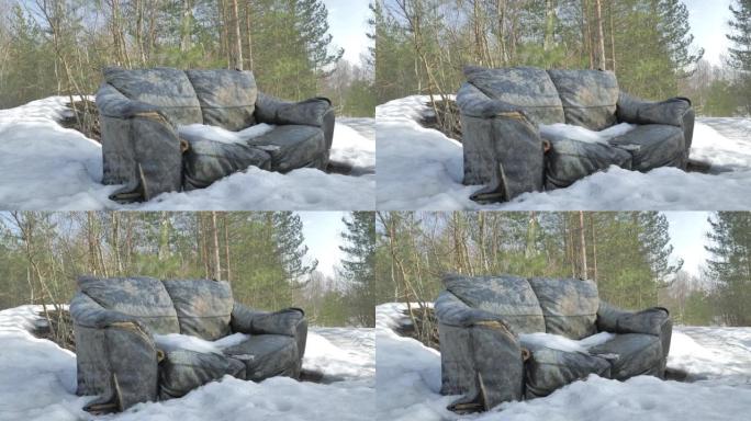 冬季在森林中废弃沙发的特写镜头。